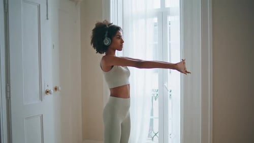 African Lady Stretching Hands at Domestic Place. Slim Focused Woman in Sportswear