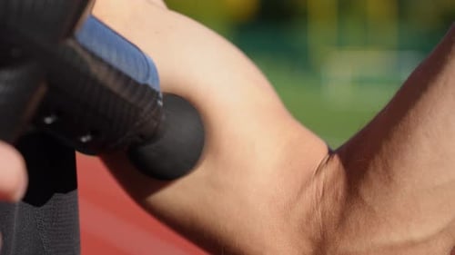 Adult Massaging Arm with Massage Gun Close Up