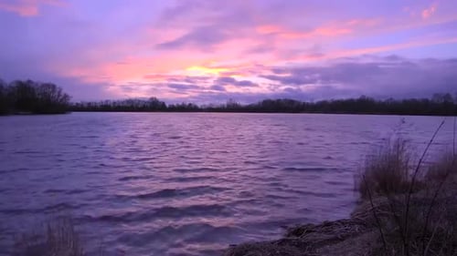 Time lapse or timelapse footage of an evening or dusk yellow, orange and red sky with clouds moving.