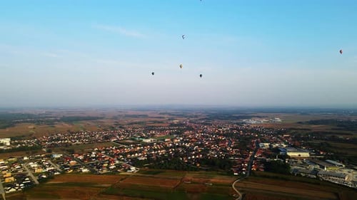 Stunning 4K aerial footage of a drone filming hot air balloons. Flying over farming fields and river