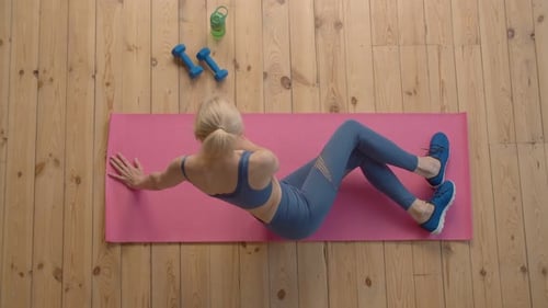 Top View of Pretty Sporty Fit Senior Female Exercising Yoga Side Plank at Home