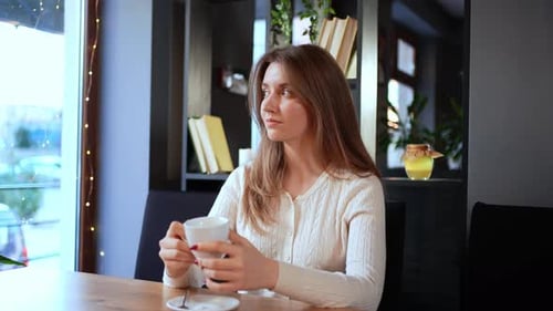 Elegant Female Drinking Coffee in Cafe