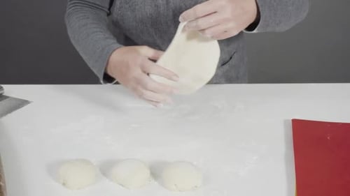 Dough Being Rolled Out with a Wooden Pin