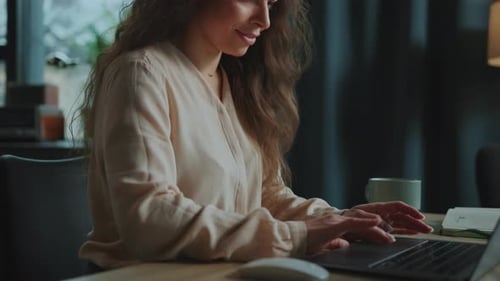 Woman Typing on Laptop Computer at a Table