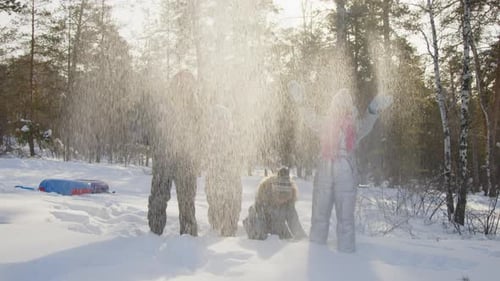 Gruppe von Kindern, die weichen Schnee im Winterwald werfen