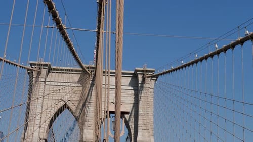Slow motion pan of building arches of the iconic Brooklyn Bridge New York City CBD Manhattan barrier