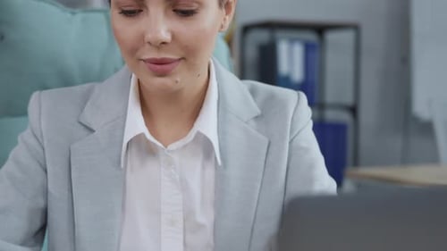 Woman Writing in Notebook at Office Desk