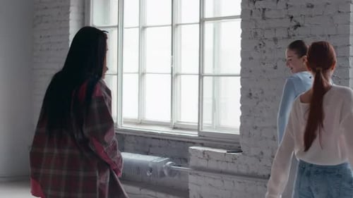 Trainer Helping Girls with Dance Moves in Minimalist Studio