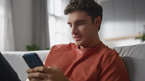 Man Relaxing at Home Using Smart Phone