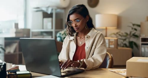 Woman Typing on Laptop in Office Setting