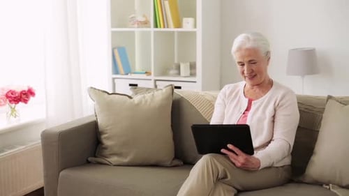 Senior Woman Relaxing on Couch Using Tablet
