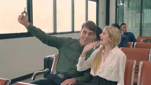 Passenger traveler couple in airport gate taking selfie photo together by smartphone