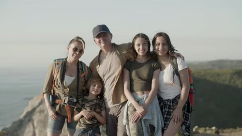 Happy Caucasian Family Hiking Together Standing on Cliff