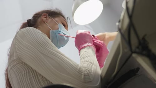 Woman Performs Nail Art Wearing Mask and Gloves
