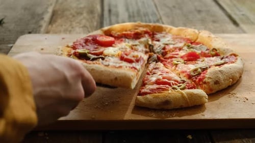 Hand Taking Slices of Baked Homemade Pizza