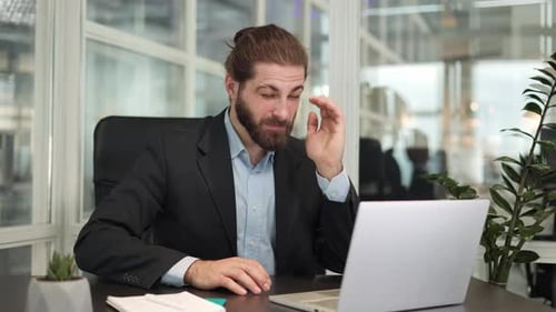 Frustrated Man Working at Computer in Office