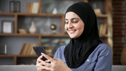 Smiling Woman Using Smartphone in Living Room