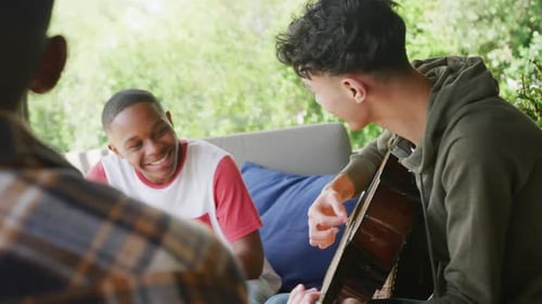 Young Friends Relaxing, Playing Guitar