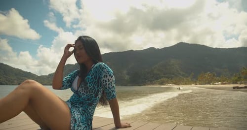 A girl enjoying a model shoot on the beach with her hair blowing in the wind and epic cloudscape in