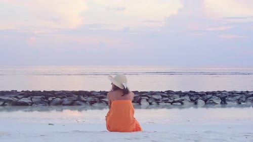 Mujer sola sentada en la playa