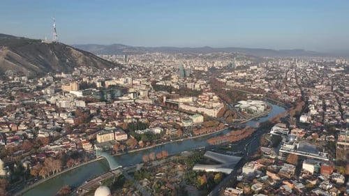 Aerial panoramic view of Tbilisi, Georgia, with the Kura River, city center, and Mount Mtatsminda
