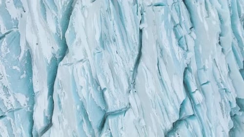 Aerial view above details on light blue glacier surface, in Vattnajokull, Iceland - top down, drone