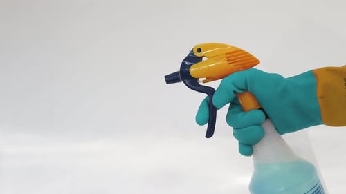 Spraying Bottle with Blue Liquid in Protective Glove