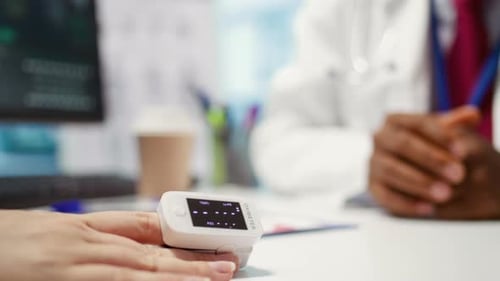 Doctor Checks Patient's Oxygen Level with Oximeter