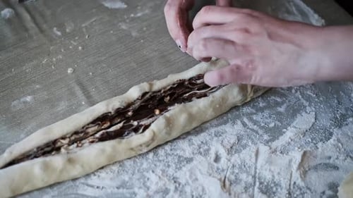 Woman Rolling Dough with Rolling Pin on Table