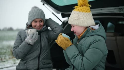 Mother and Teen Daughter Drinking Hot Beverage in Winter