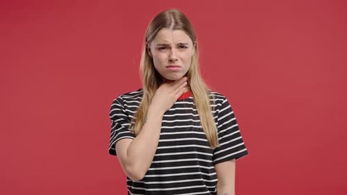 Mulher bonita tem dor, mulher doente, garganta inchada no estúdio vermelho Angina Flucold