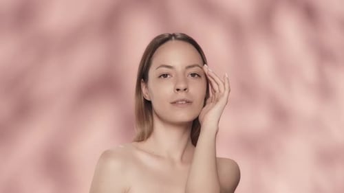 A Woman Demonstrates Her Smooth Clear Healthy Skin Woman Smiling Touches Her Face in the Studio on a