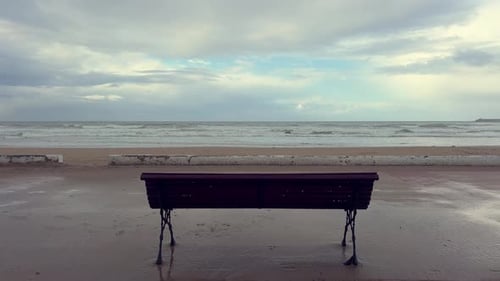 Bank vor dem Hintergrund des Meeres oder Ozeans mit Wellen und einem wunderschönen Himmel mit Wolken