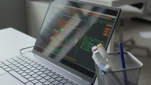 Laptop with Software Interface and Circuit Board Parts with Wires on Desk