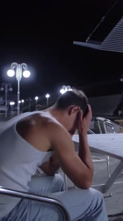 Man Sitting Alone at Table at Night