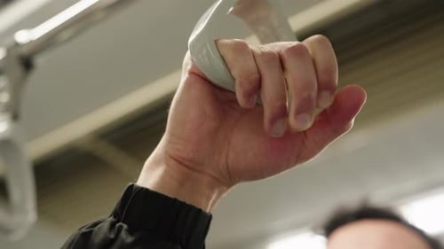 Sangle de maintien à la main à l'intérieur d'une rame de métro pendant le trajet