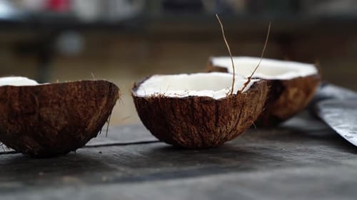 Halved Coconuts With White Flesh On Wooden Surface