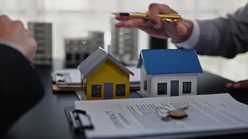 Corporate Meeting at Desk with House Models and Keys