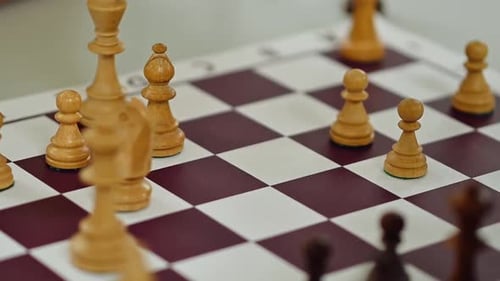 Nahaufnahme einer Hand, die eine Schachfigur auf dem Brett bewegt. Schachturnier, Wettbewerb, Schachbrett