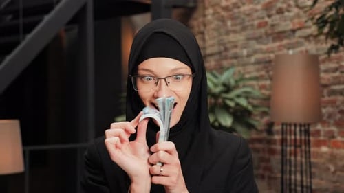 Woman Smiles with Stack of US Dollar Currency