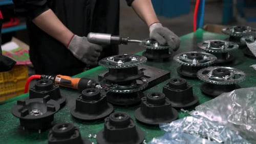 Chinese Factory Worker Installs Component During Engine Assembly Line
