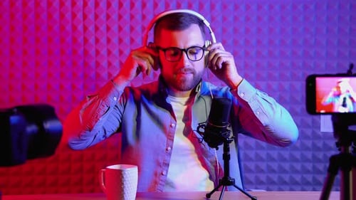Vlogger Using Microphone and Headphones to Record Vlog for Channel