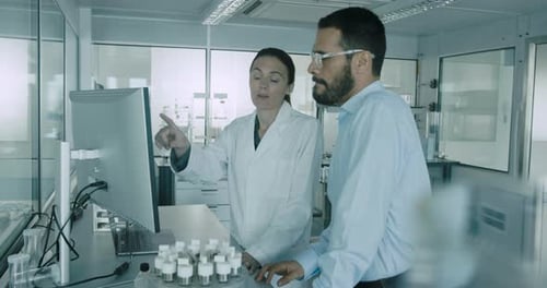 Scientists Reviewing Data on Computer Screen in Lab