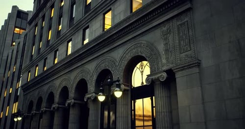 Detalles arquitectónicos de un edificio histórico con ventanas brillantes al anochecer