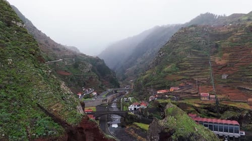 Misty Valley with Steep Green Terraces and Winding Road