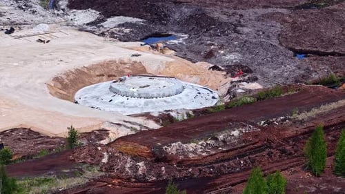 Fundación circular de turbina eólica en construcción rodeada de campos de turba y equipos