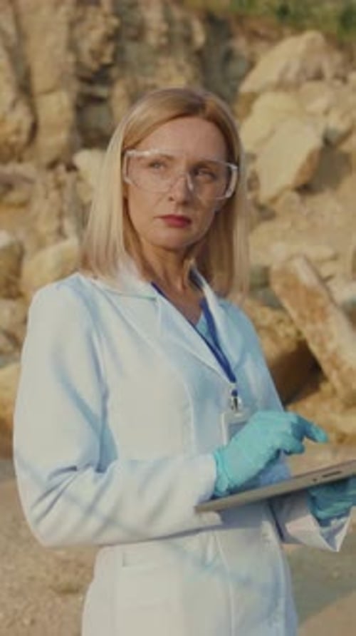 A Dedicated Female Scientist Carefully Analyzing Data While Working Outdoors in Nature