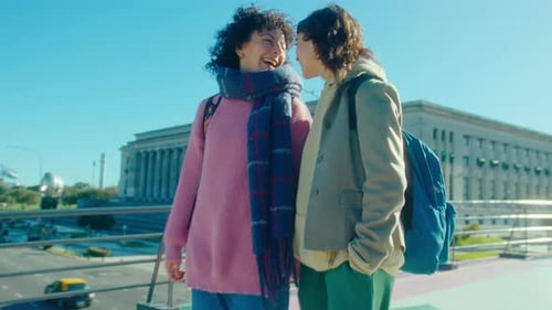Joyous Lesbian Girlfriends Holding Hands and Laughing on a Walk