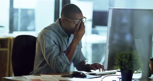4k-Videomaterial eines jungen Geschäftsmannes, der gestresst aussieht, während er spät in einem Büro gearbeitet hat