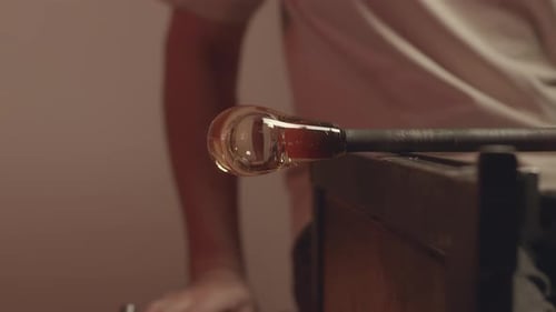 Glassblowing Crafter Molding Piece of Glass in Workshop